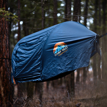 Ultralight hammock tent suspended between trees, ideal for outdoor camping and backpacking adventures. Compact, lightweight design ensures easy portability and setup. Perfect shelter solution for nature lovers seeking comfort and convenience in the wilderness